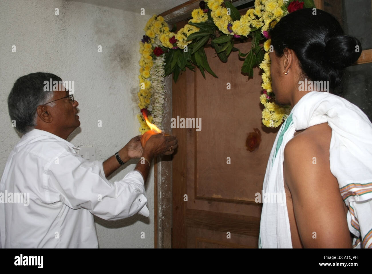 Owner of new home blesses the front door with arti or fire puja , Vaastu pooja ceremony , India Stock Photo