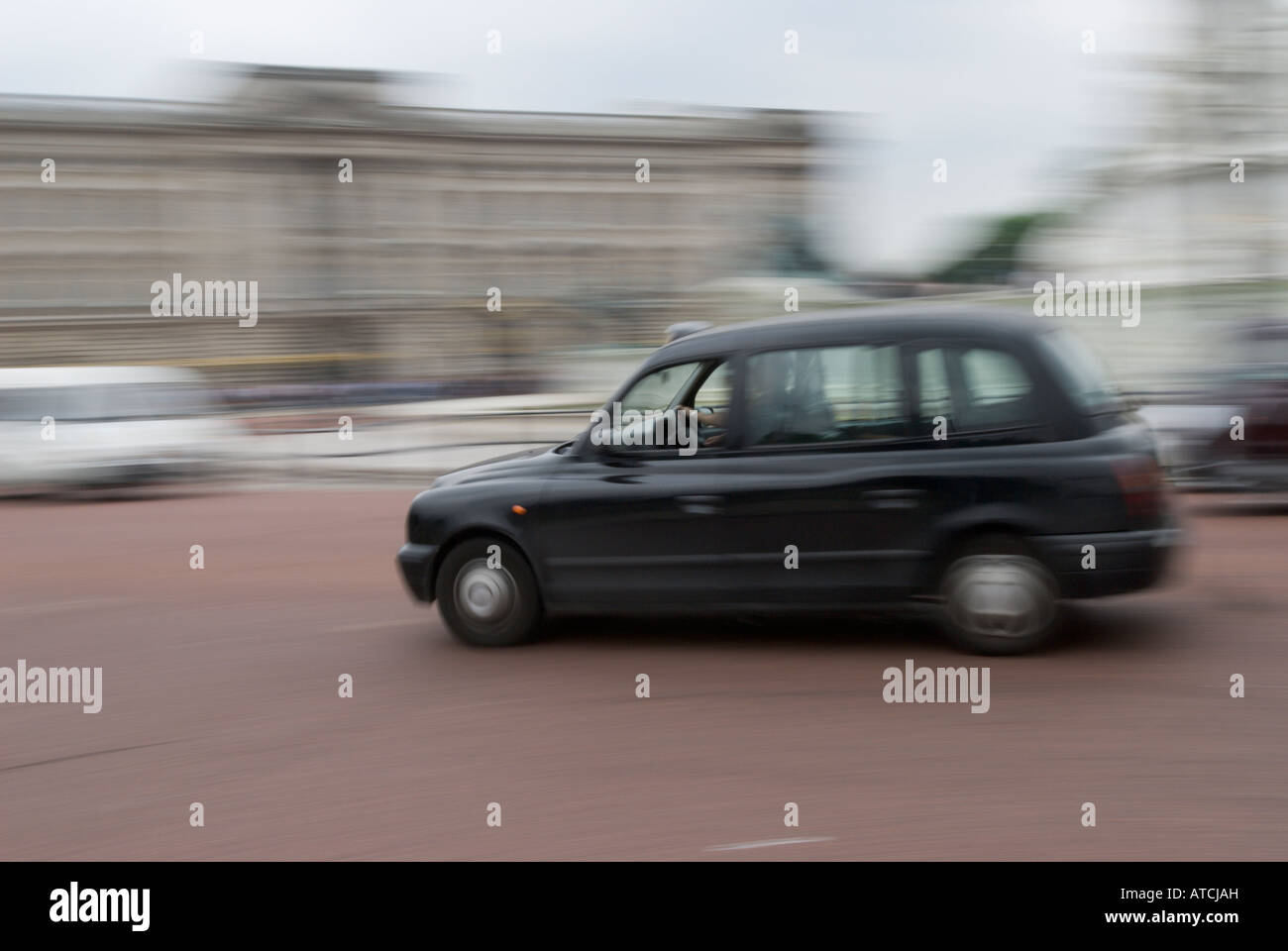 A black cab speeds past Buckingham Palace UK Stock Photo