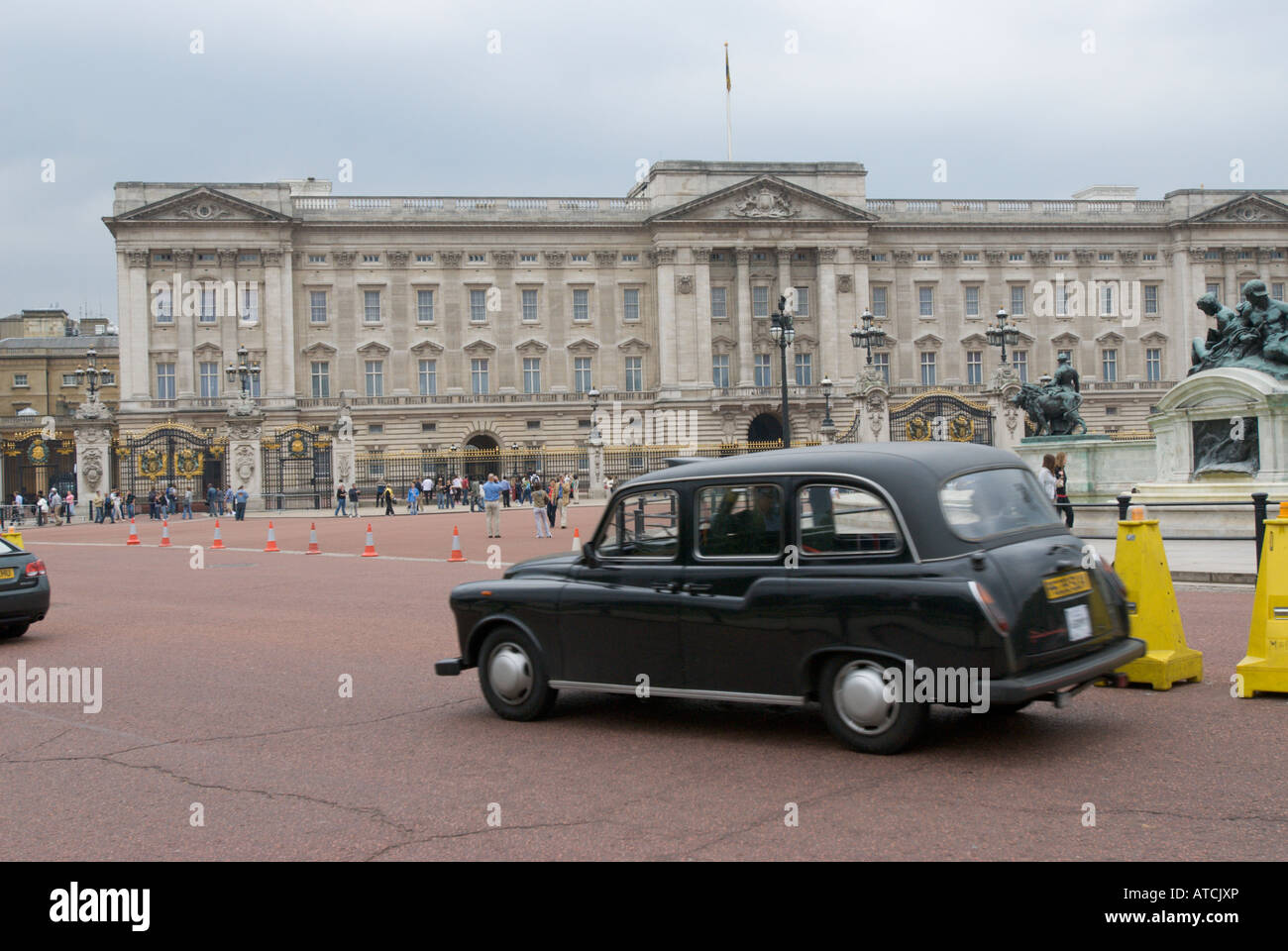 A black cab speeds past Buckingham Palace UK Stock Photo