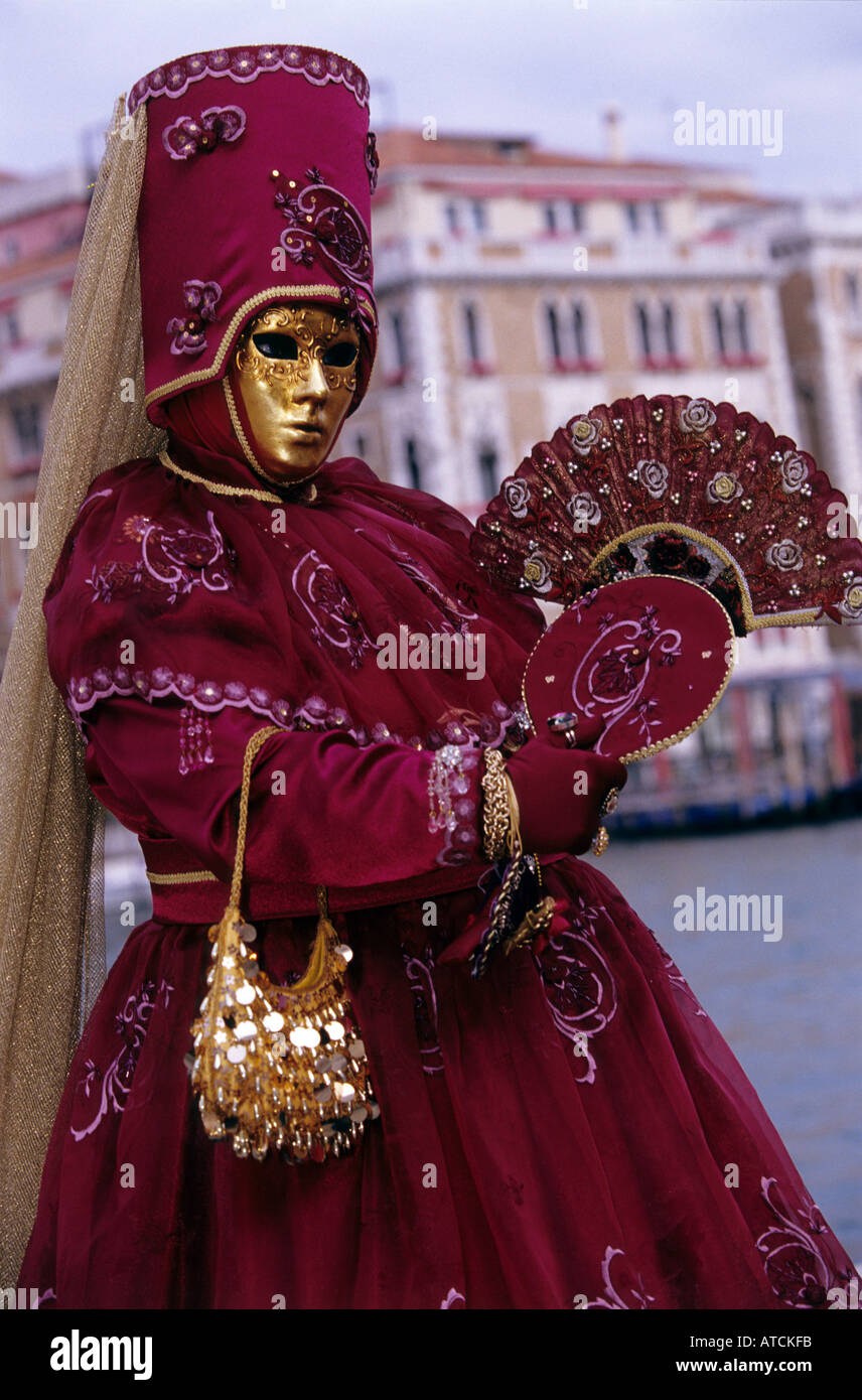 A female masquerader wearing venetian mask and beautiful red costume in Carnival of Venice 2005 Stock Photo