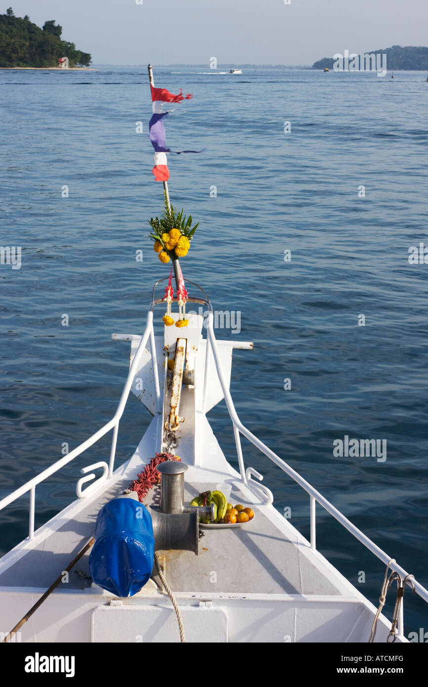 Holy place on front of a Thai boat with offering of fresh fruit Stock Photo
