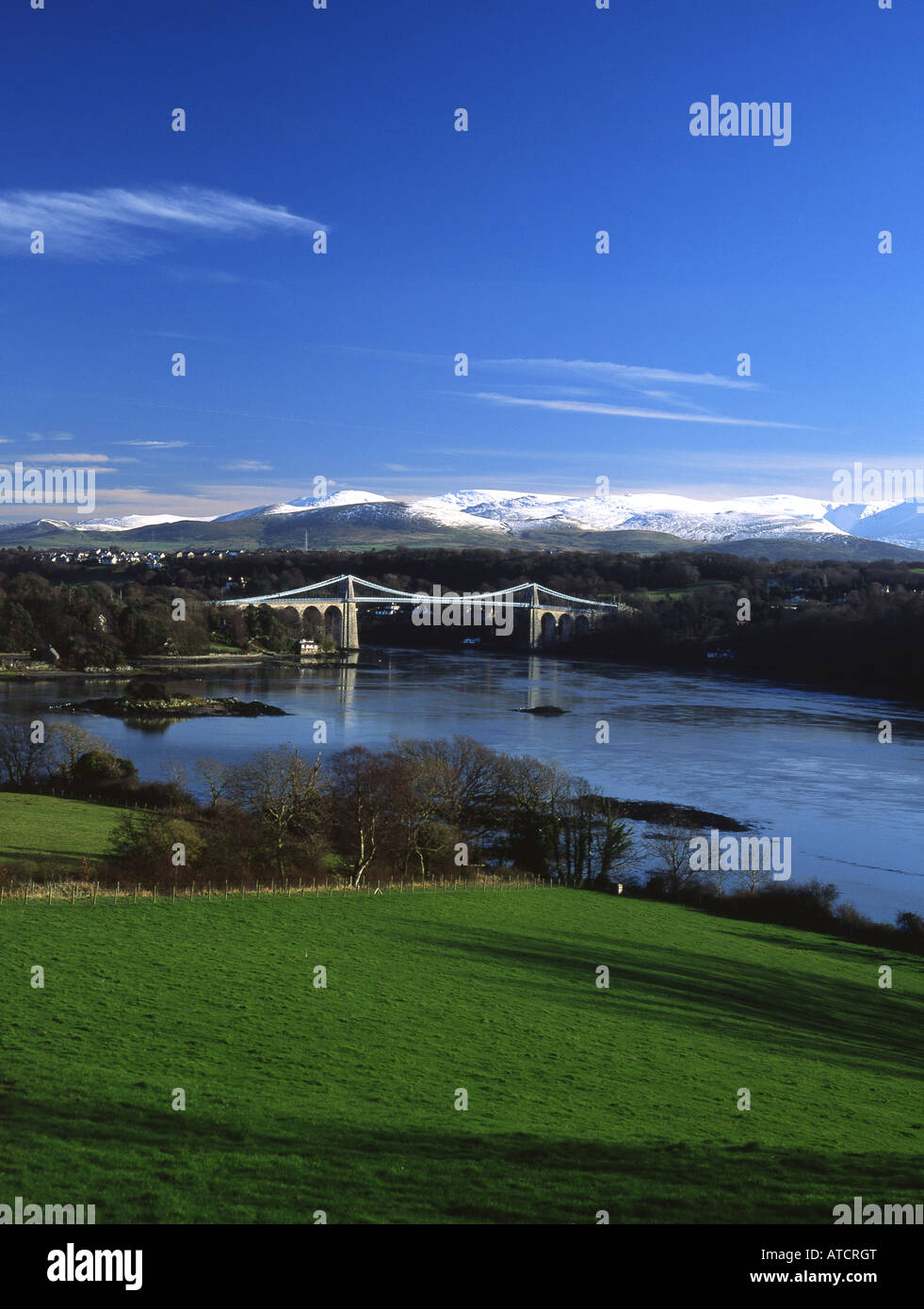 Menai Suspension Bridge Snowdonia in snow in background Anglesey