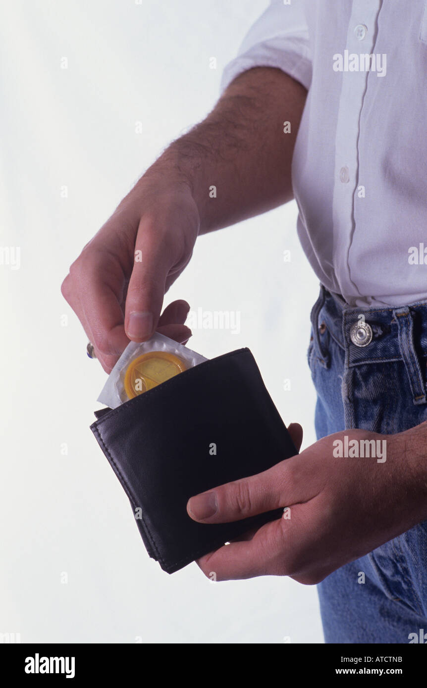 Man pulling condom out of his wallet studio set up with white backdrop