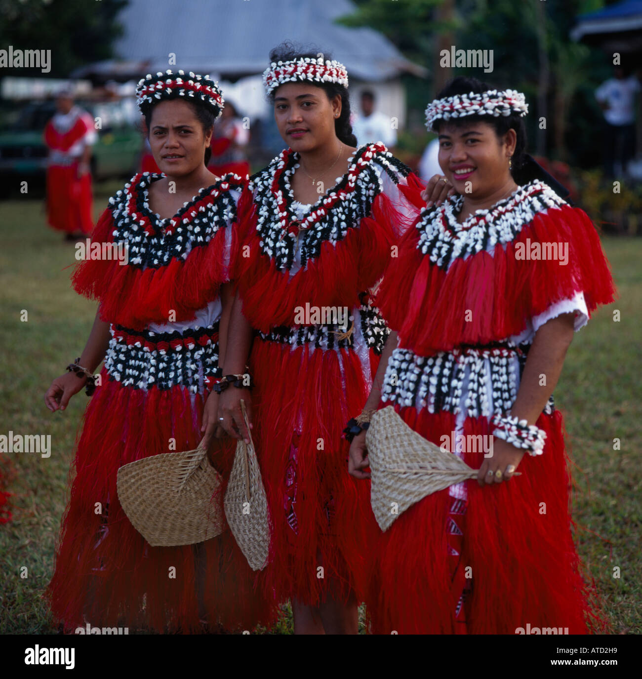 Three female dancers wearing costumes of red and white decorated with shells from the Wallis Islands in the South Pacific Stock Photo