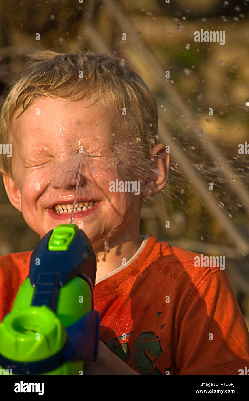 boy squirting face with water Stock Photo