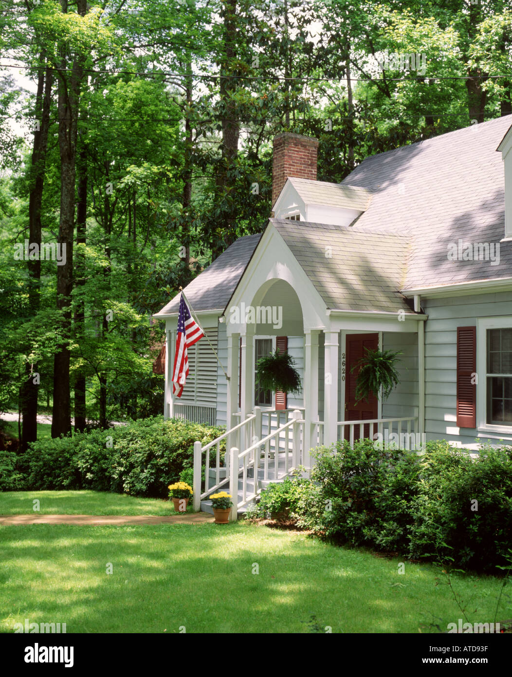 View of a restored white one story house with an arched front porch Stock Photo