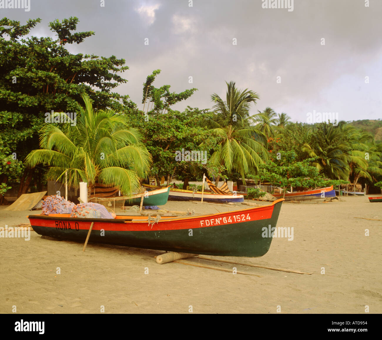 Colorful fishing boats sit on the sandy shore in Case Pilote Martinique Stock Photo