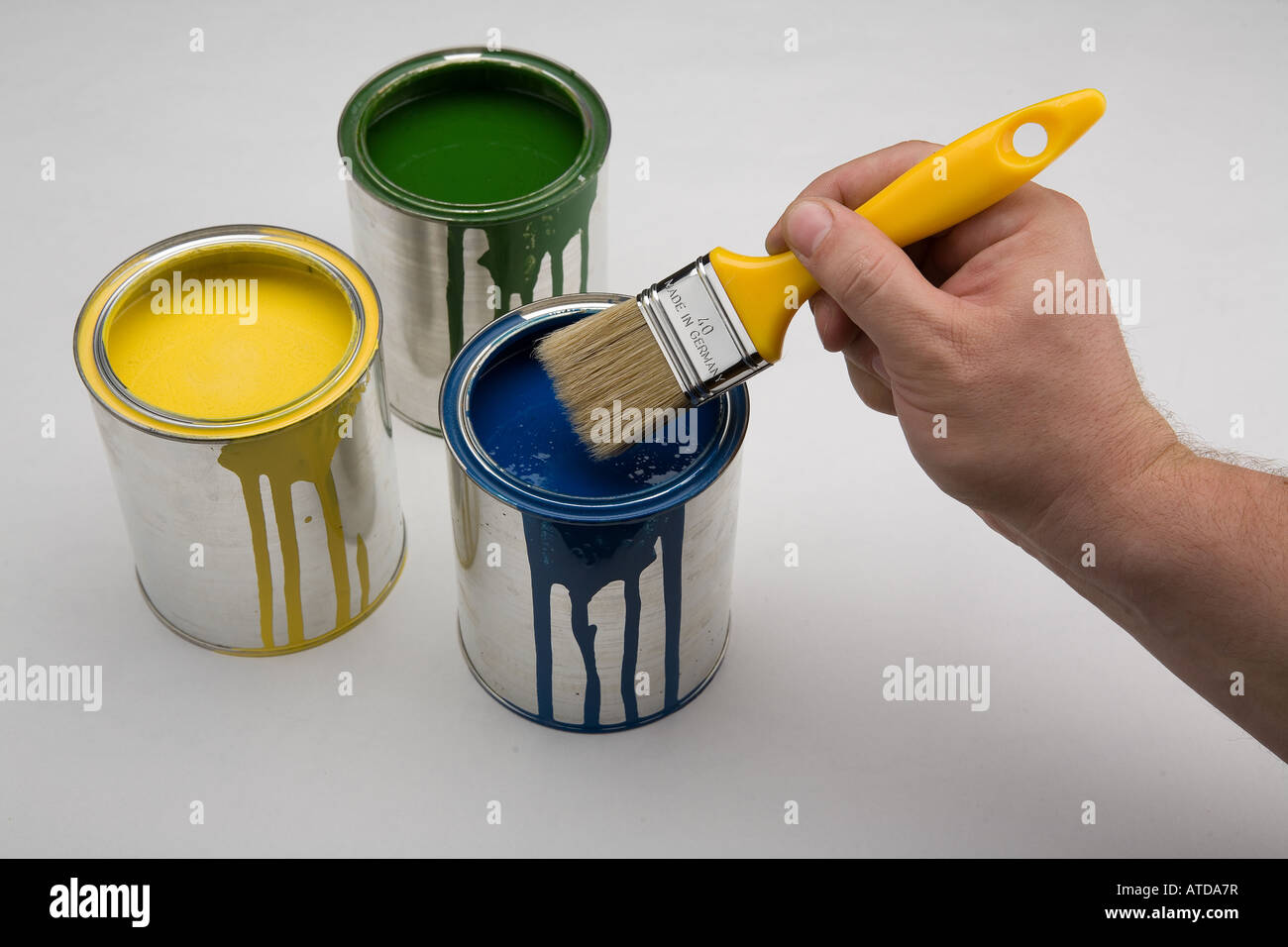 yellow, green and blue color in cans with brush Stock Photo