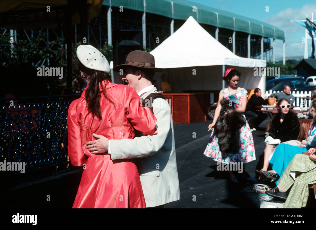 Couple in forties period dress dancing with onlookers in similar costumes Stock Photo