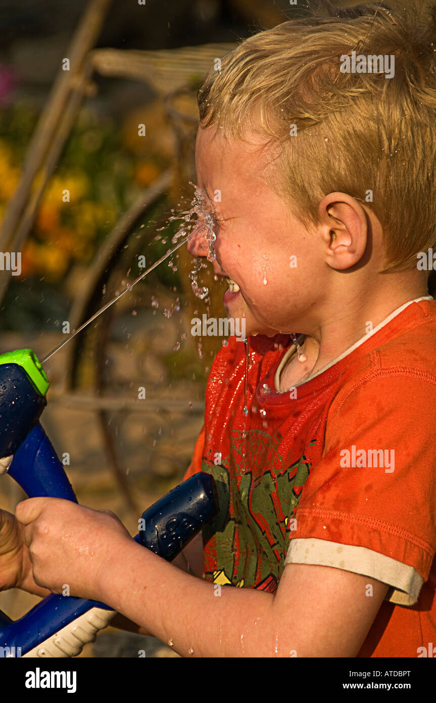 boy squirting face with water Stock Photo