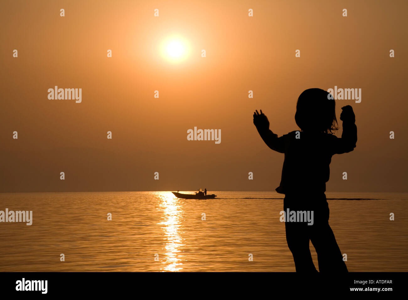 Silhouette of girl standing by lake Stock Photo - Alamy