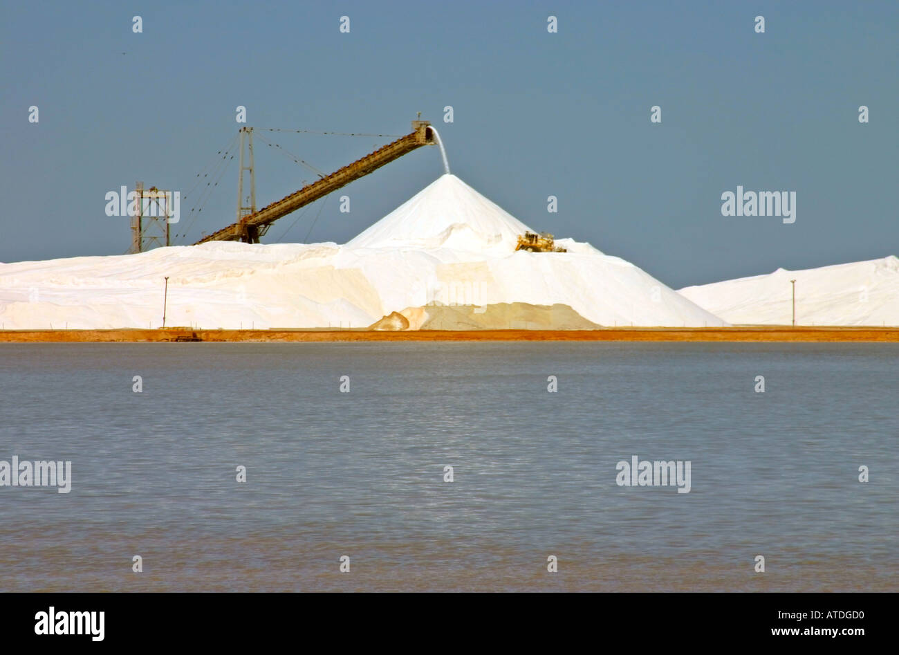 Bulldozer spreading salt around huge pile at salt works near Port Hedland Western Australia