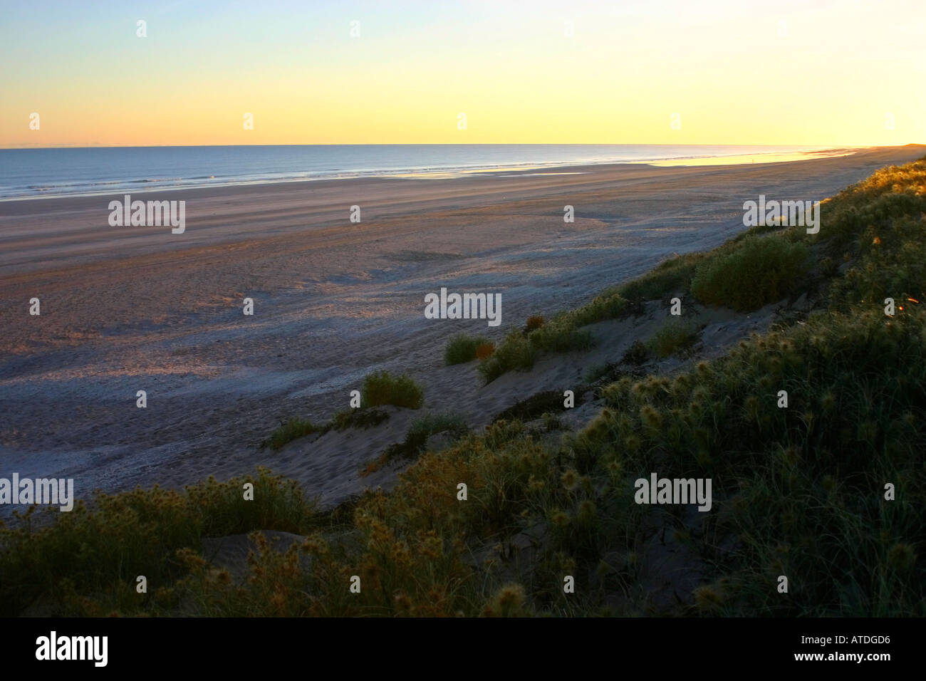 Deserted Eighty Mile Beach along blue Indian Ocean waters at sunrise between Port Hedland and Broome in Western Australia Stock Photo