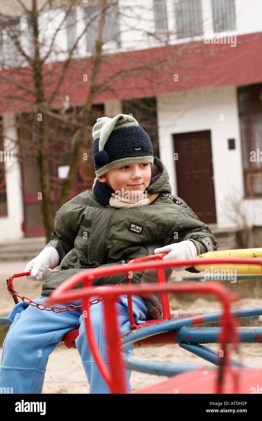 Children Playing on Merry-go-round in park Stock Photo