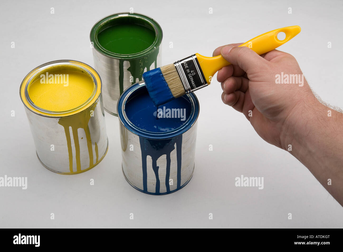 yellow, green and blue color in cans with brush Stock Photo Alamy