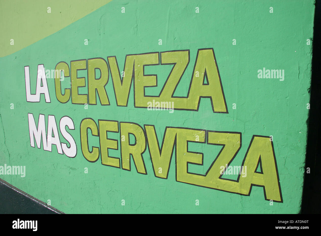 Green and white sign advertising beer reading La Cerveza Mas Cervesa painted on the side of a building in Cusco Peru Stock Photo