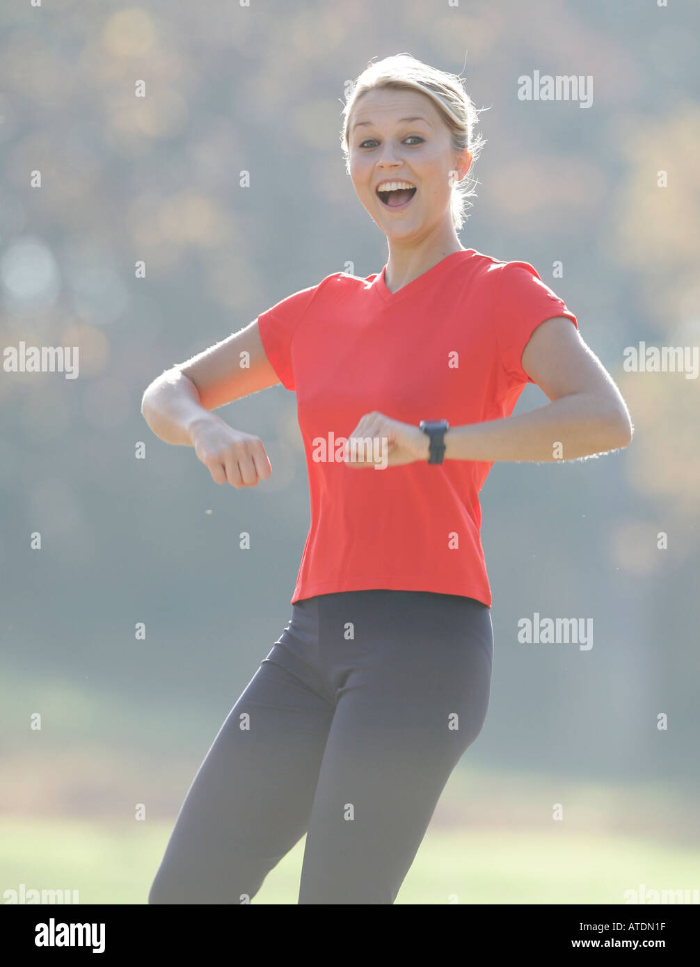 young woman leaping up enjoying exercising in the park Stock Photo