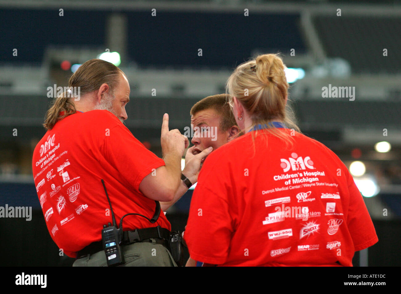 A trainer checks an injury during the wrestling competition in the AAU Junior Olympics in