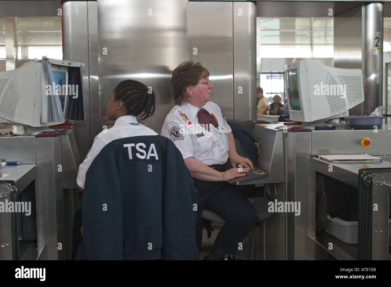 Airport security screeners view the contents of travellers luggage on