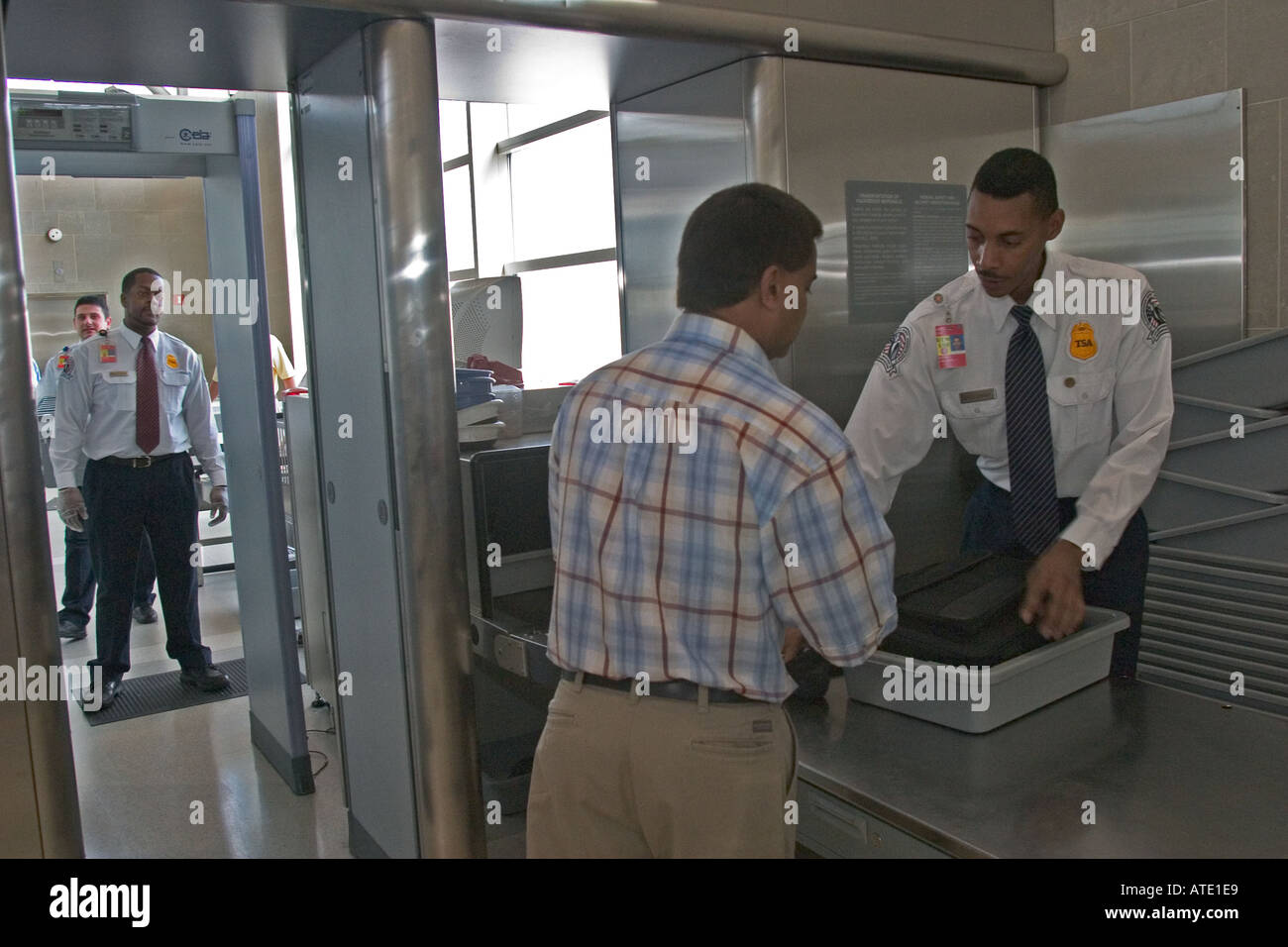 An airport security screener checks a traveller s luggage at Detroit