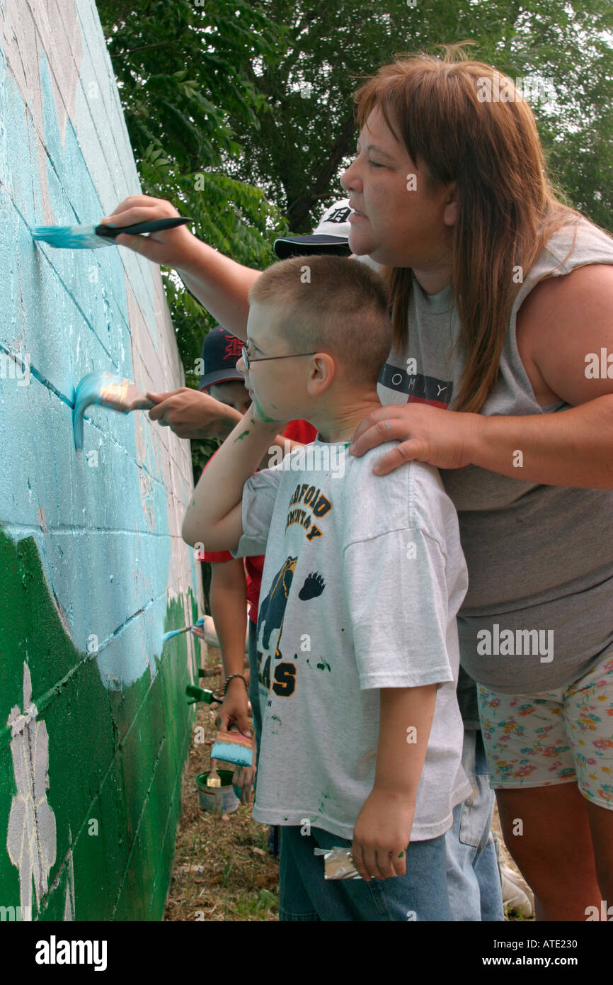 Volunteers paint a wall in a poor neighborhood in Detroit Stock Photo