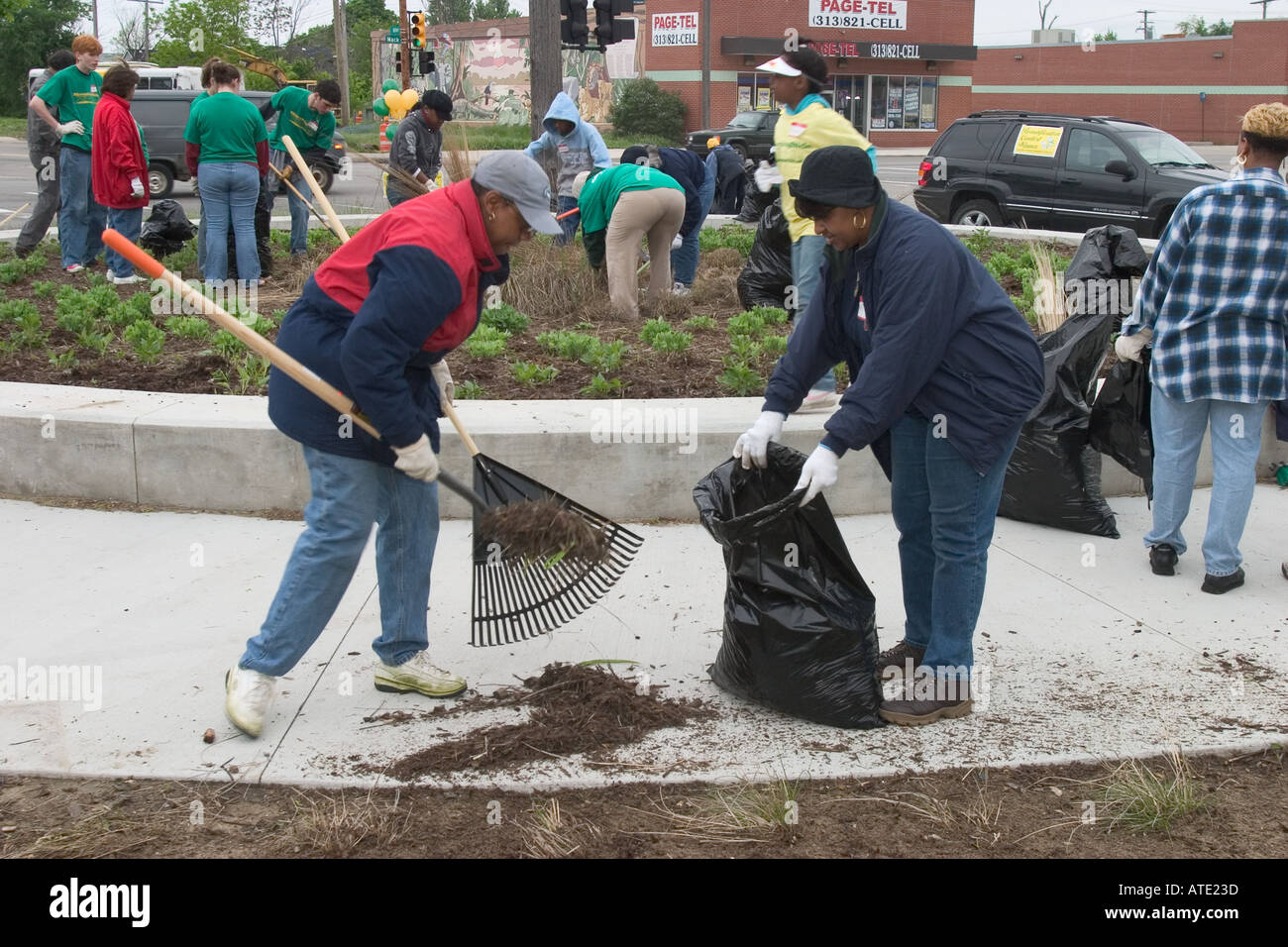 Voluteers clean and plant flowers in neighborhood park in Detroit Stock Photo