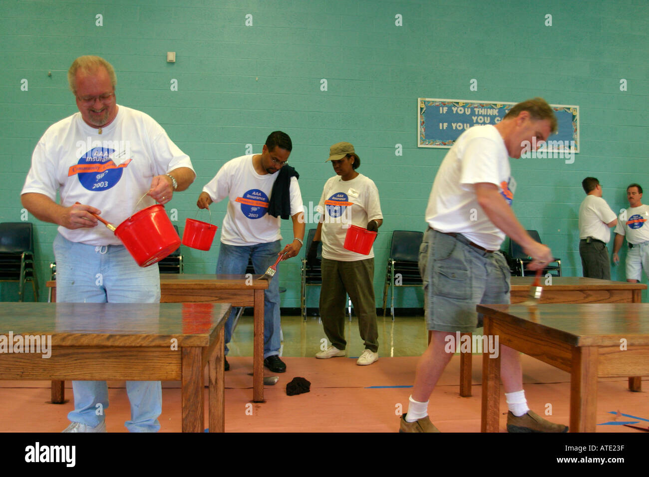 Volunteers stain tables in classroom of Detroit school Stock Photo