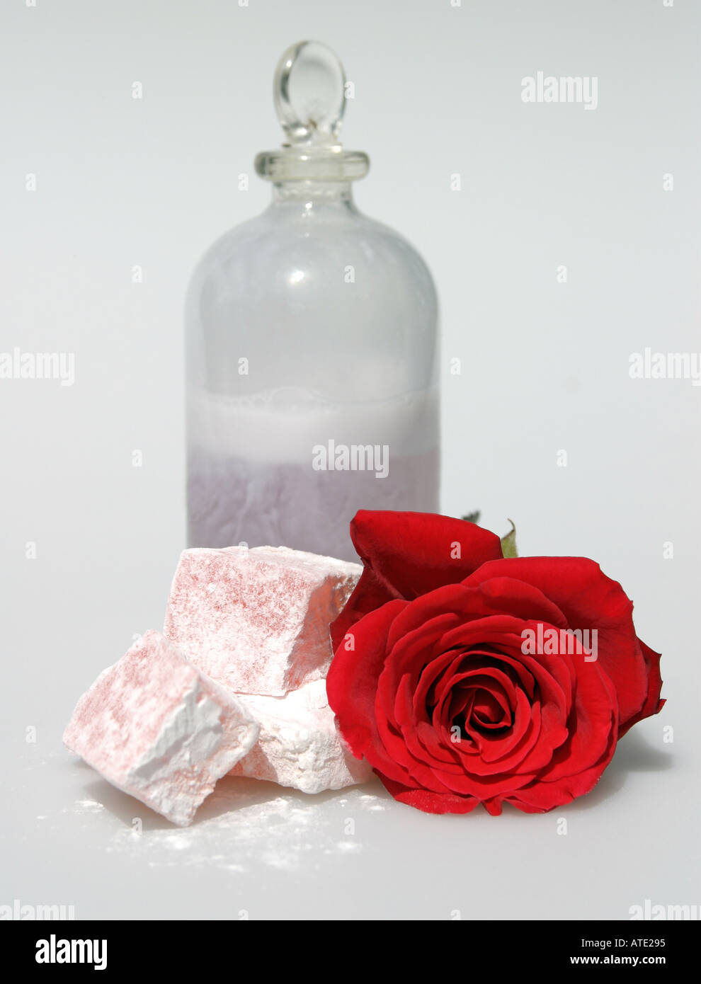 Science of the rose. How roses are used. Red rose and bottle of rose