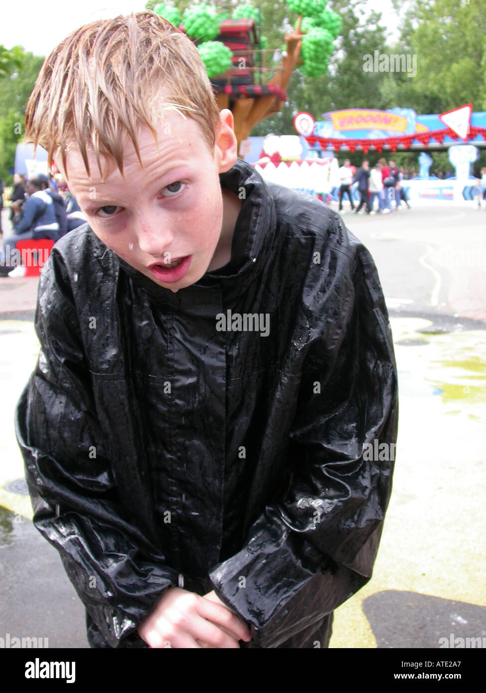 wet boy at a theme park looking helpless and miserable Stock Photo