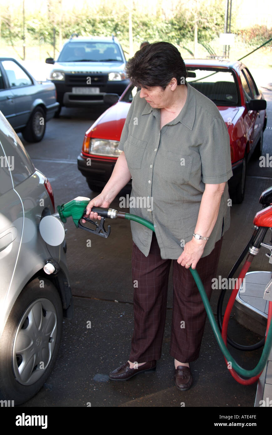 London Tesco Extra supermarket filling station forecourt model released mature woman filling up with petrol into Toyota Yaris hatchback car England UK Stock Photo