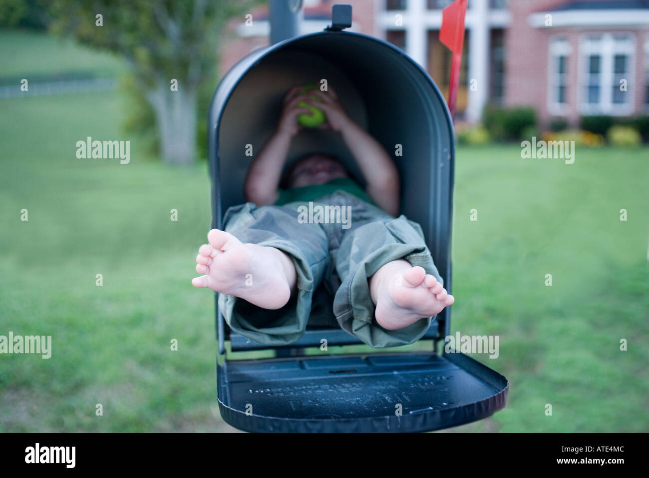 Young boy in mailbox Stock Photo
