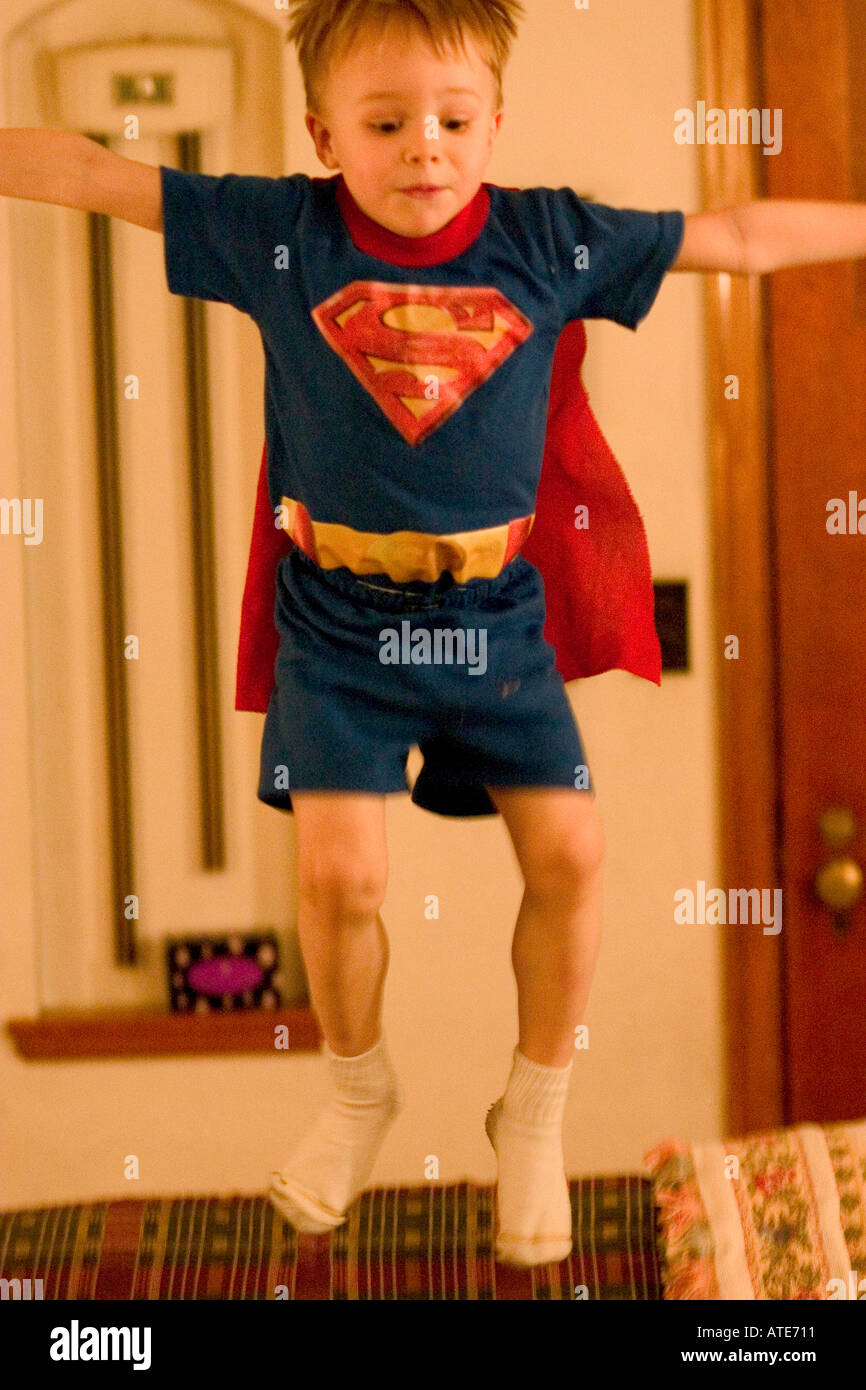 Superman taking a flying leap off couch while his mother was in the other room. St Paul Minnesota MN USA Stock Photo