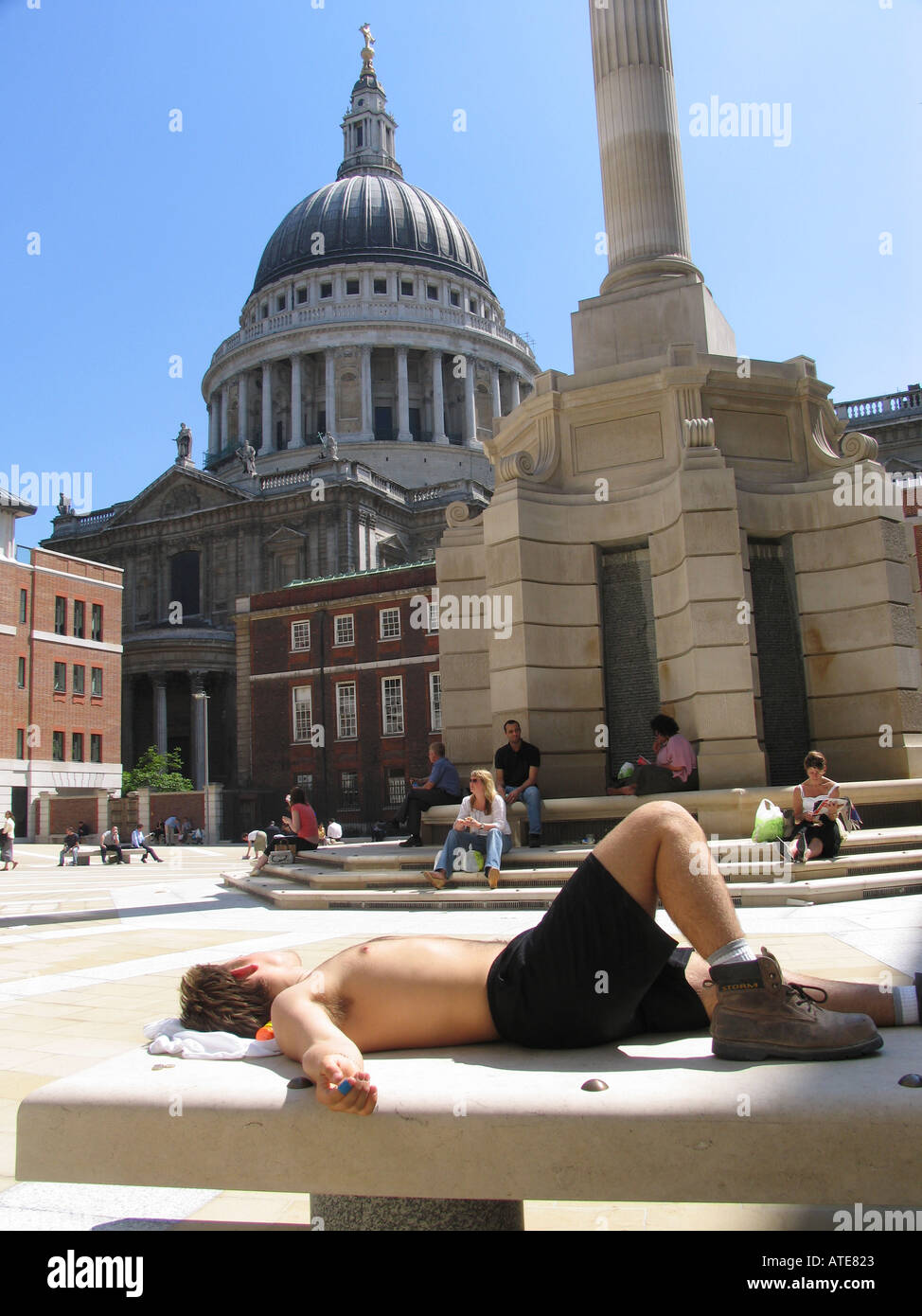 Man resting over a bench in Paternoster square on a hot summer day London England UK Stock Photo