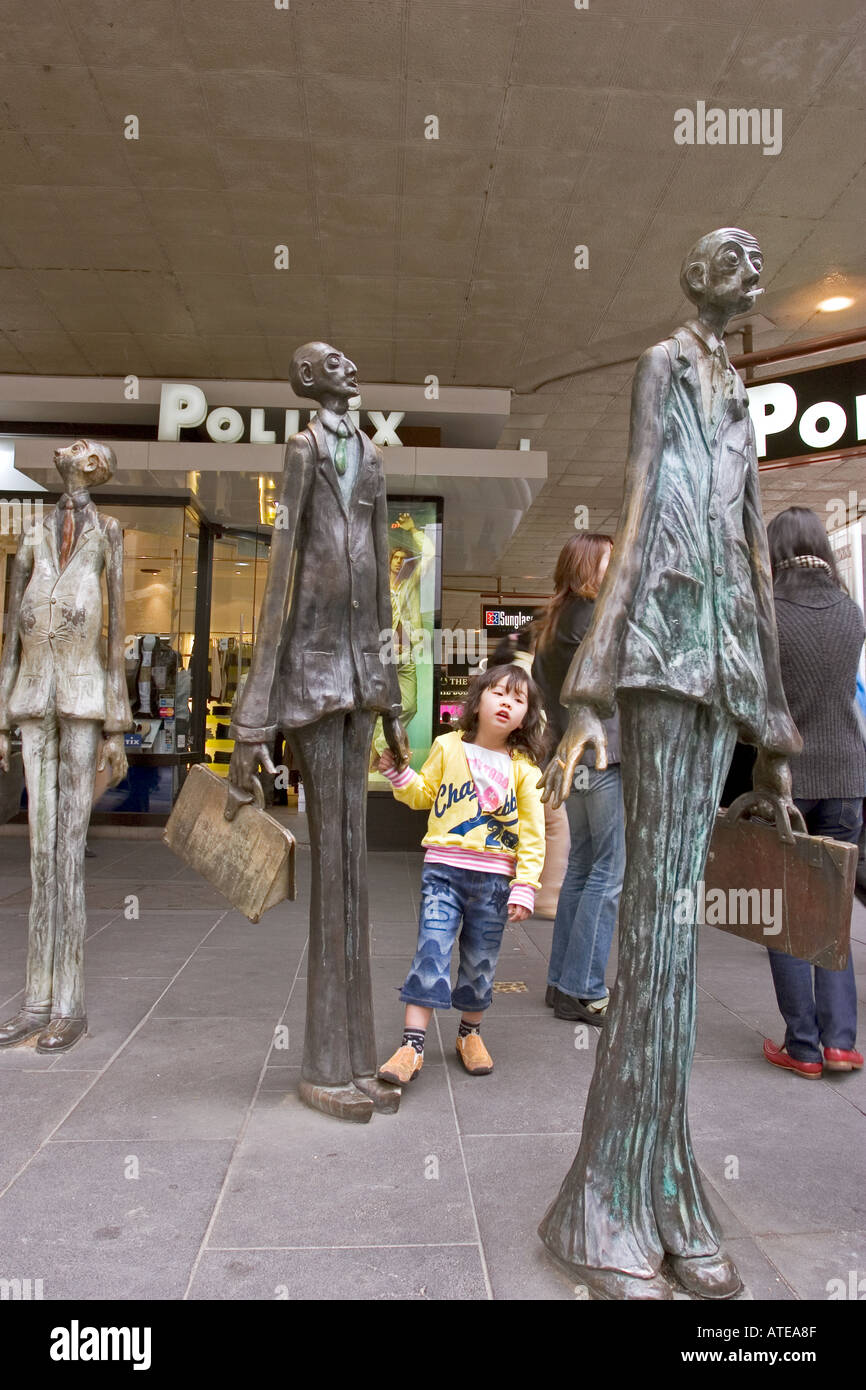 Small girl stares in awe at unusual male statues in Melbourne City
