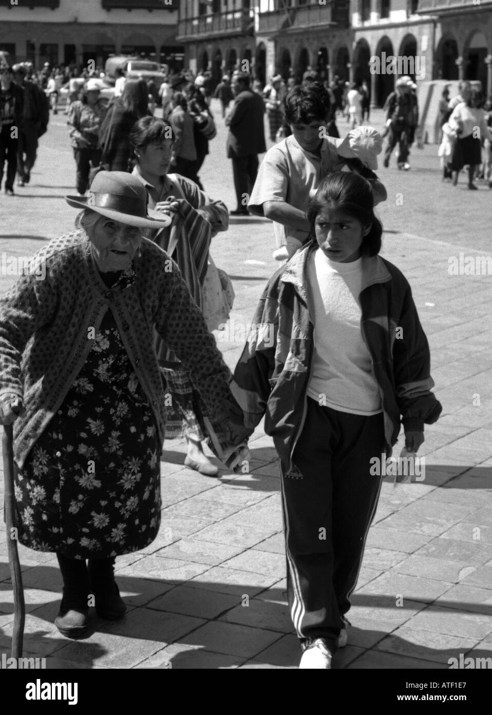 'Genes' Old woman grandmother girl granddaughter walk march together hold hands lean pass on Cuzco Peru South Latin America Stock Photo