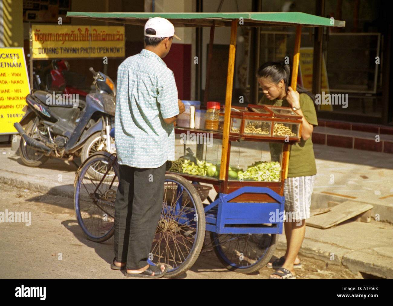 Indigenous woman man with mobile three wheel pedal bicycle kiosk sell ...