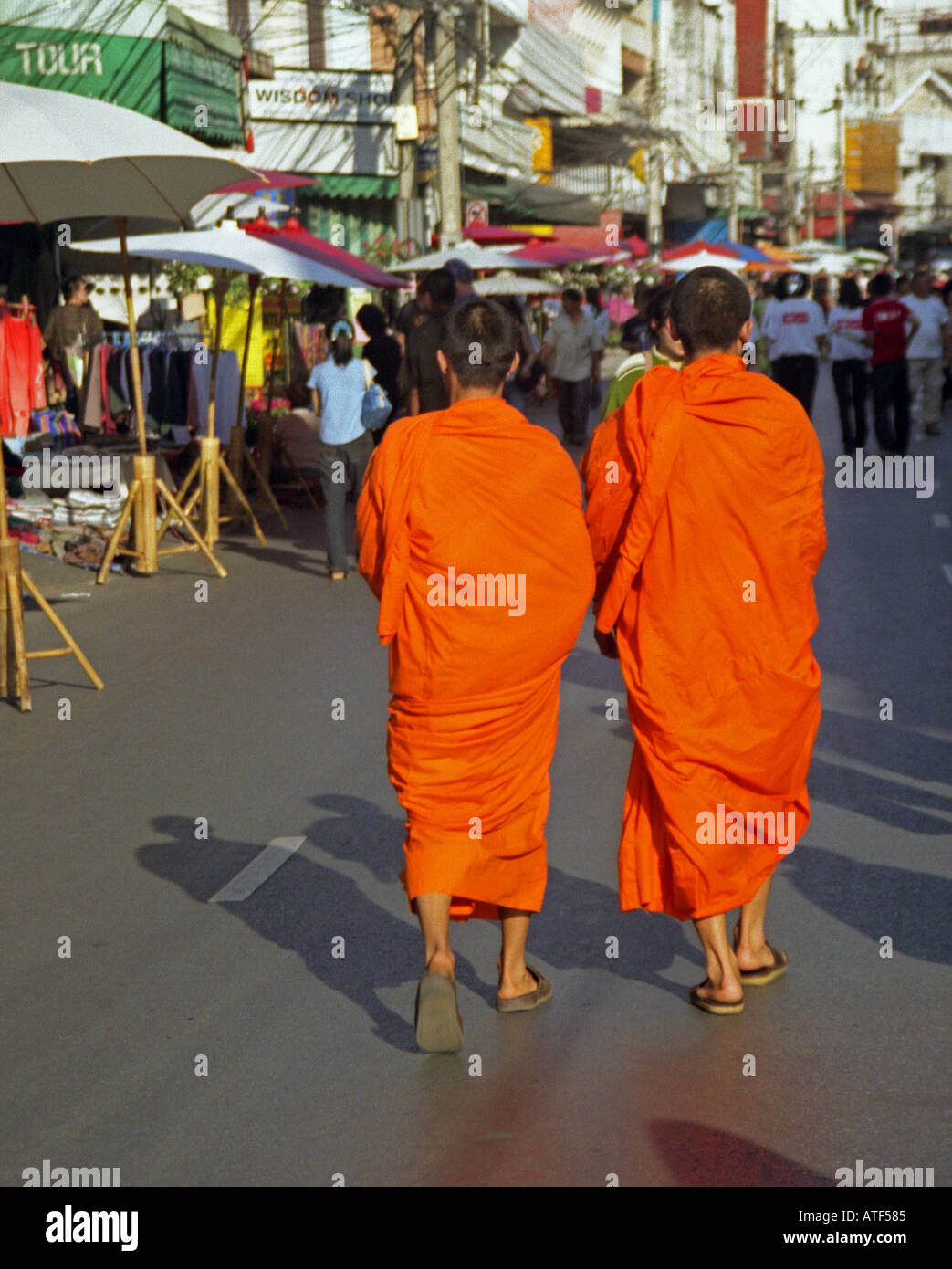 Pair of shaved head novices traditional colourful robe walk march together Anusan Market Chiang Mai Thailand Southeast Asia Stock Photo
