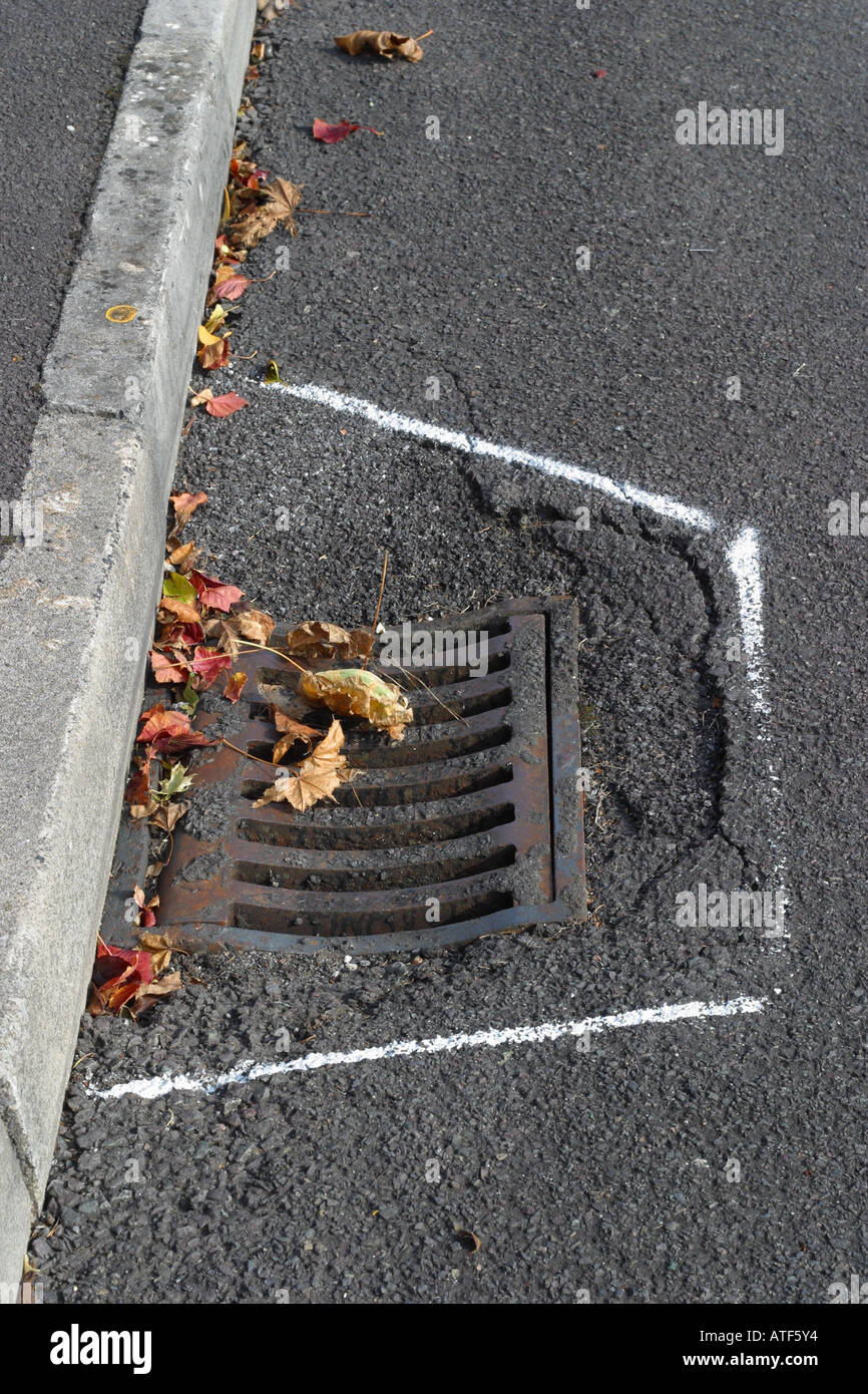 Road repairs maintenance gutter drain cover in need of repair Stock Photo