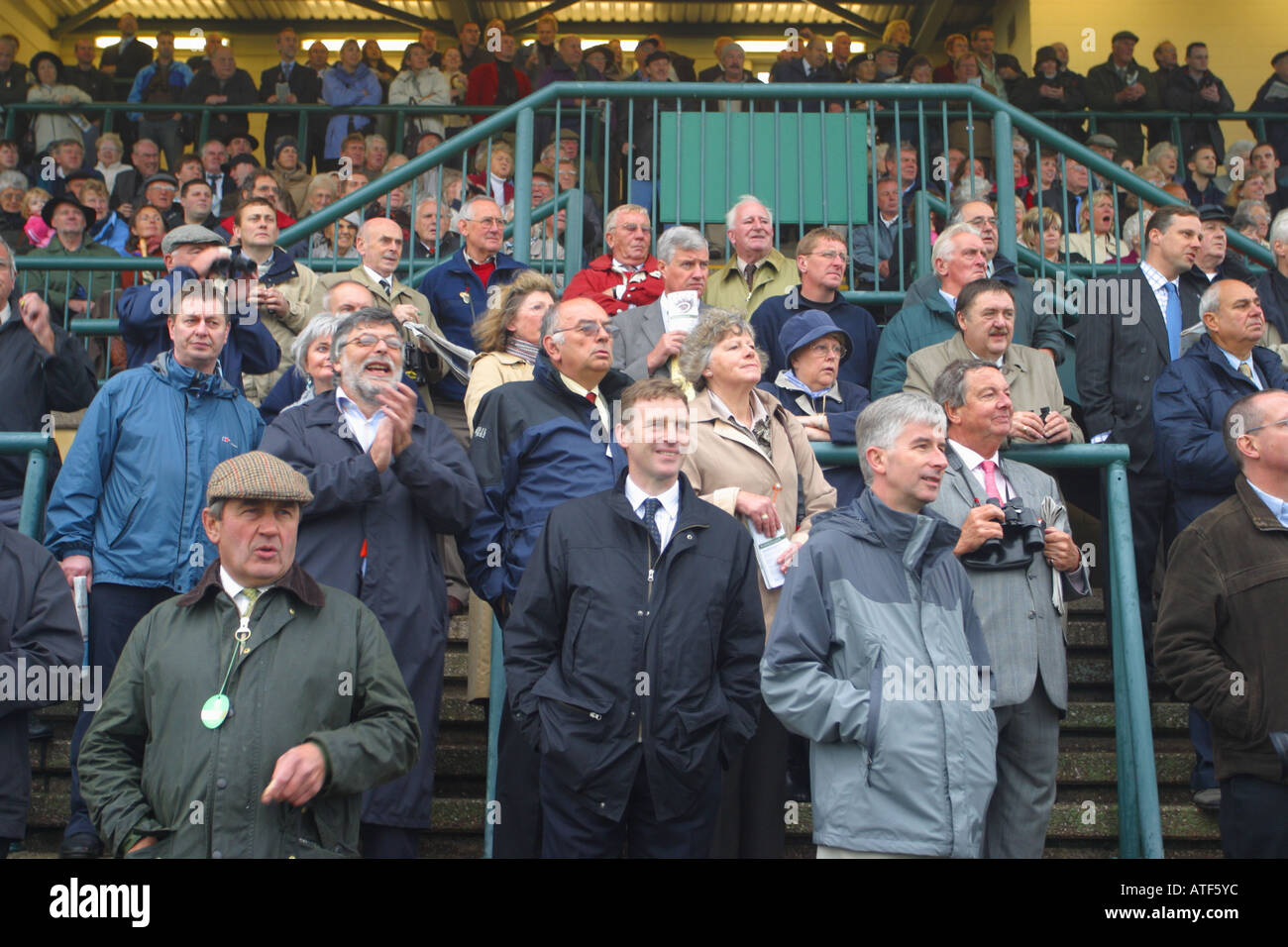 Horse racing spectators watching the closing stages of a horse race from the grandstand at Bath races October 2006 Stock Photo