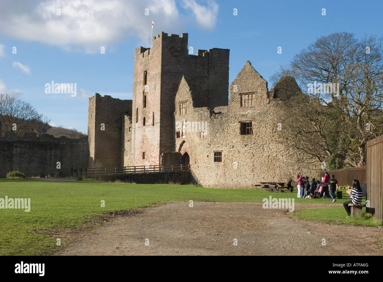 Ludlow Castle with a group of school student visitors under a blue sky