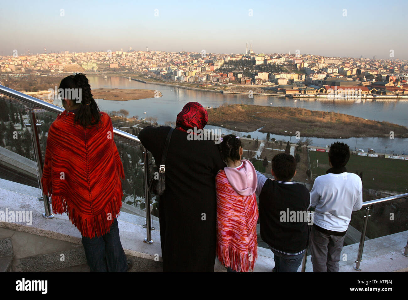 Turkish family look across the Golden Horn, from viewing platform above