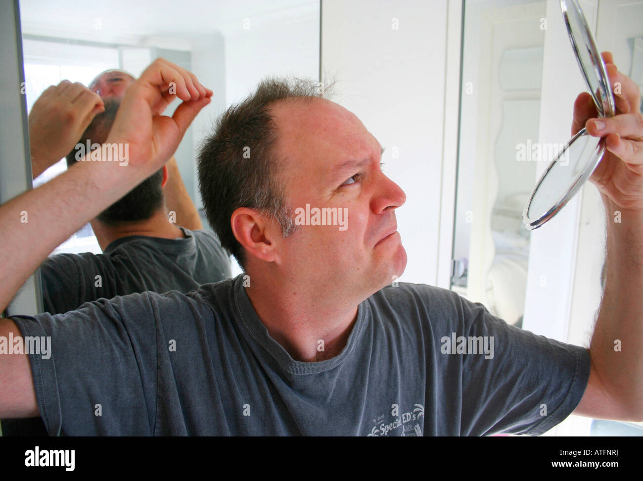 Man checking his thinning hair Stock Photo