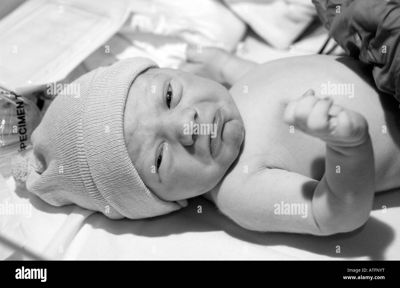 Newly born baby boy a few minutes old with hat on in Maternity ward of hospital Stock Photo