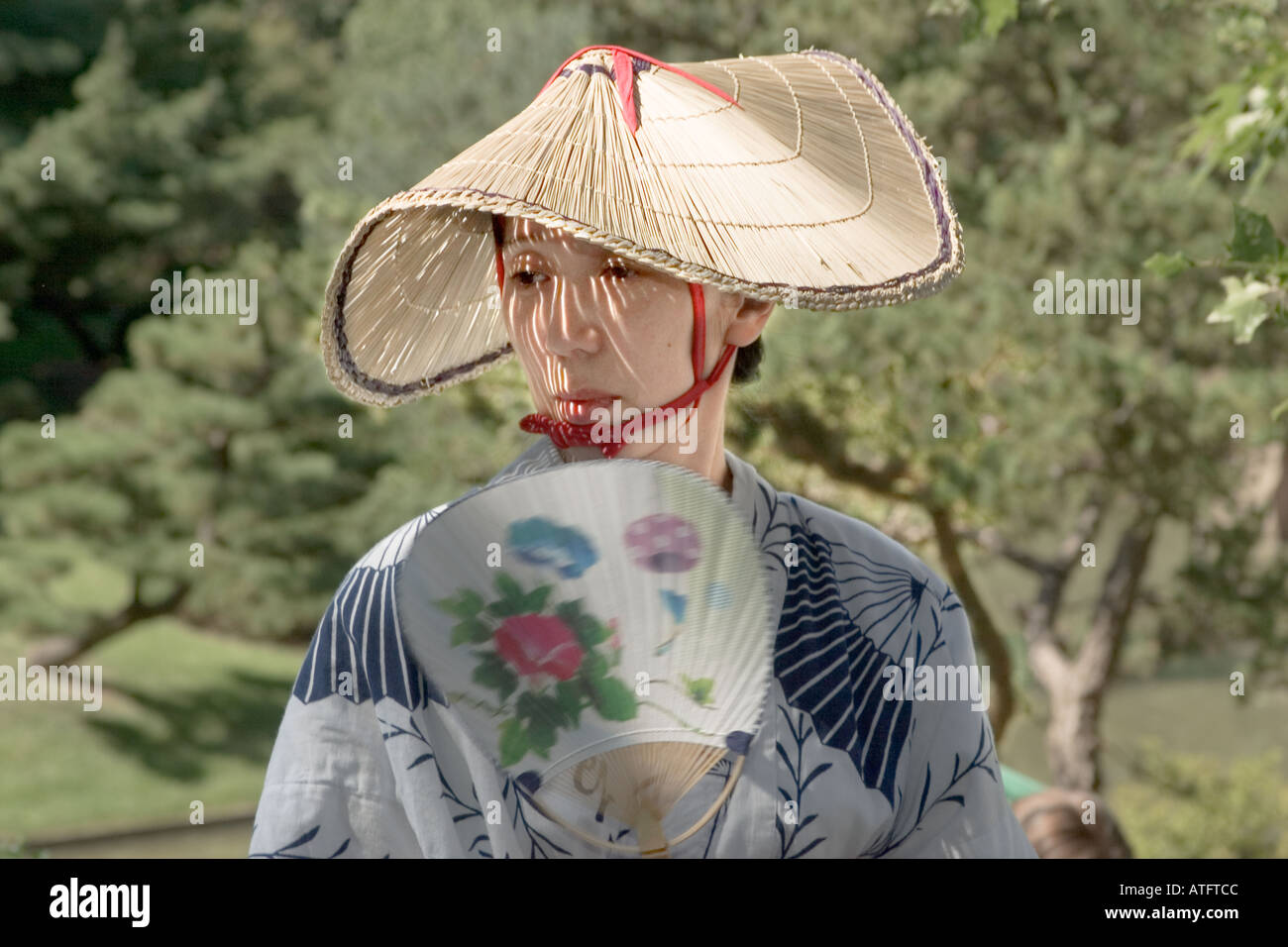 A Japanese woman in traditional dress with straw hat and fan at the annual Japanese Festival at the Missouri Botanical Garden in Stock Photo