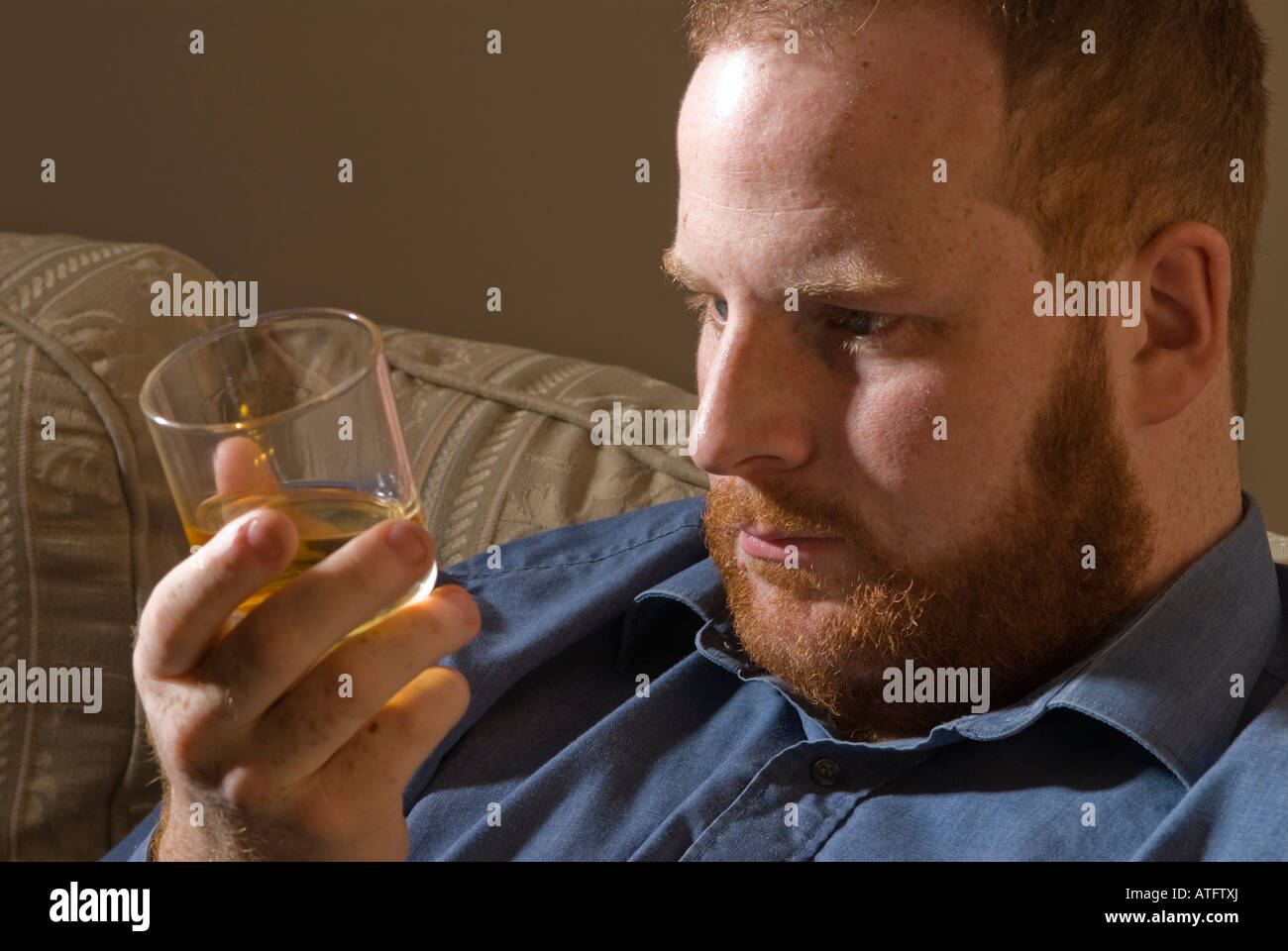 depressed tired alcoholic young man drinking Irish whiskey alcohol
