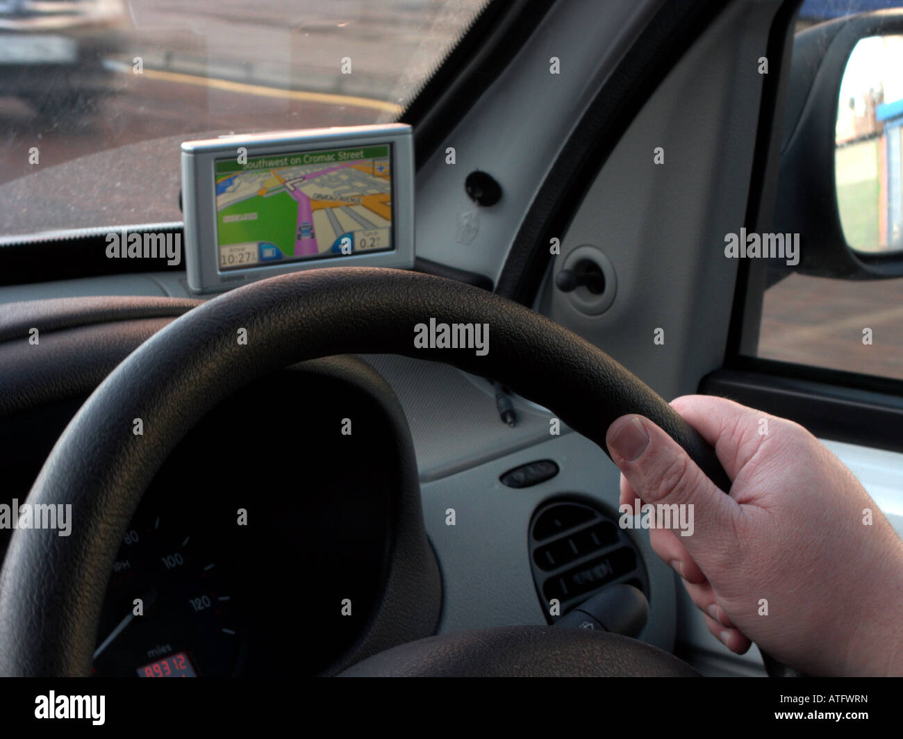 mans hand holding steering wheel of a van driving through Belfast City Centre following sat nav directions Stock Photo