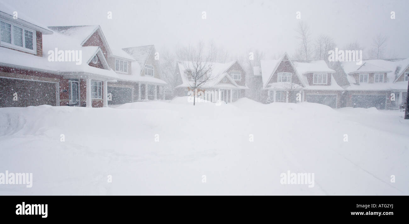 Blizzard in Suburbia. A curve of houses partially obscured by a raging blizzard and covered by deep white snow Stock Photo
