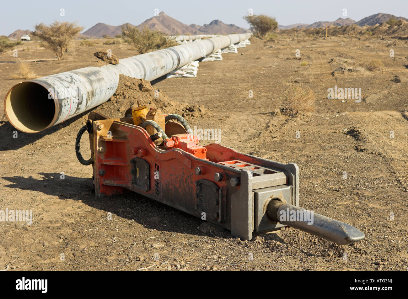 Hydraulic breaker attachment and new [water pipe] instillation across the desert and mountains near Lezaq Oman Stock Photo