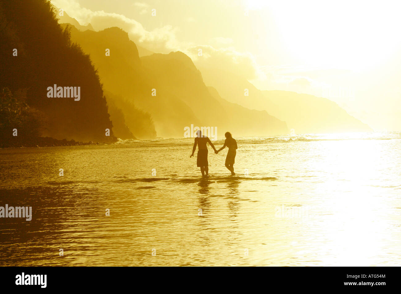 couple holding hands on sunset beach Stock Photo