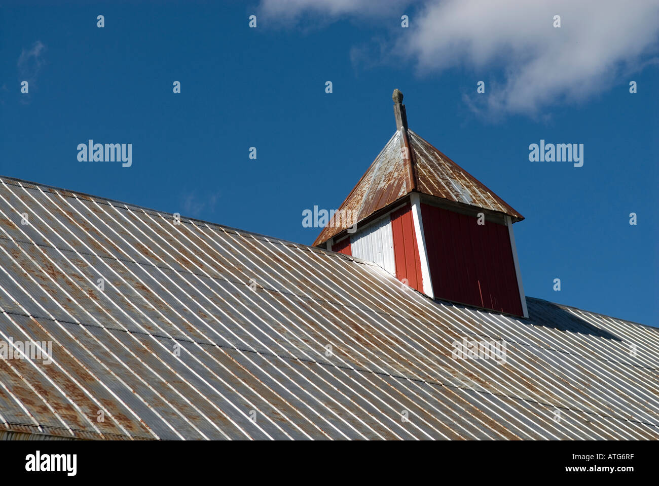 Stock image of cupola on an old red barn with metal roof in Stanley New